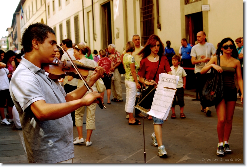 A boy playing El Choclo on Violin, before the museum Galleria dell'Accademia in Florence, Italy